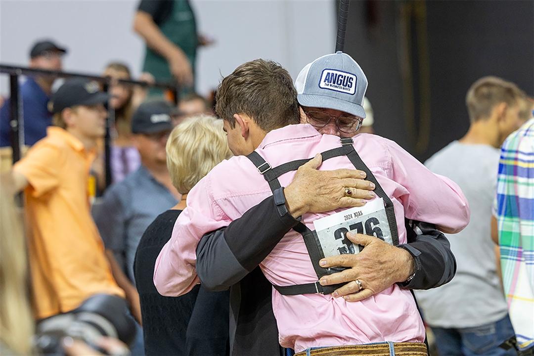 A young showman hugs his family after a win in the ring.