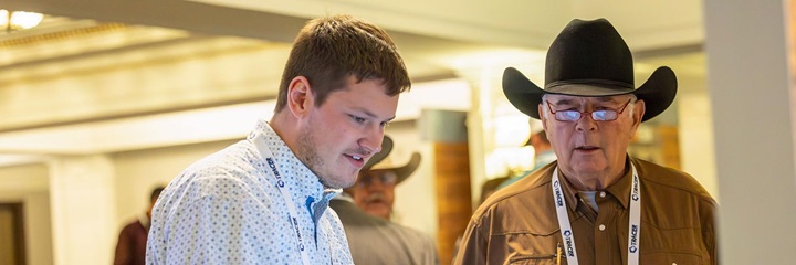 An industry showcase sponsor speaks with an Angus Convention attendee.
