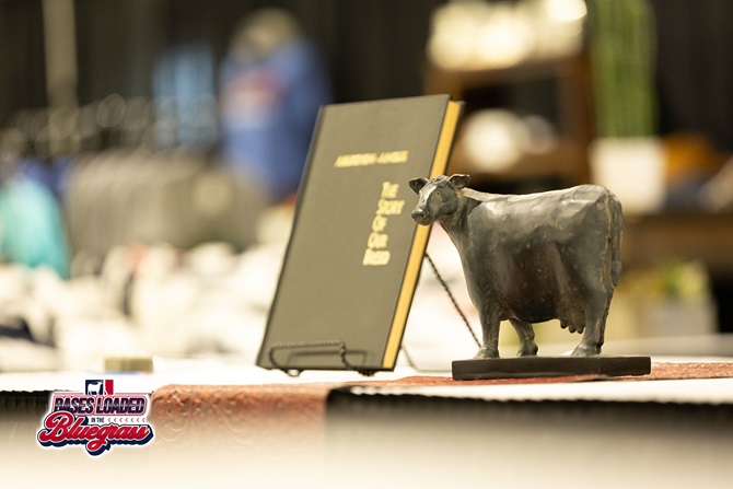 Black Angus cow figurine displayed beside a book at the NJAS Angus Foundation silent auction.