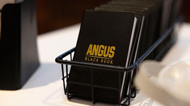 A stack of Angus black books is displayed on a table.