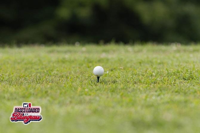 A golf ball waits on the tee box before the start of a hole.