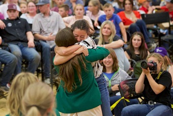 Two girls hugging in excitement after passing the Junior Board Membership green coat to one another as a new director was named.