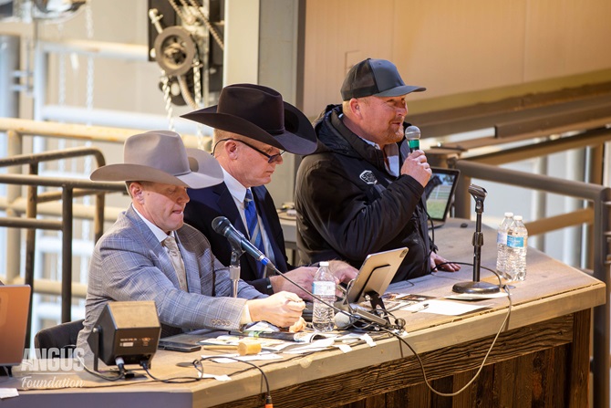 Three men sit atop the sale block at the Foundation Angus Sale.