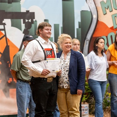 A young NJAA member accepts a scholarship at the National Junior Angus Show.