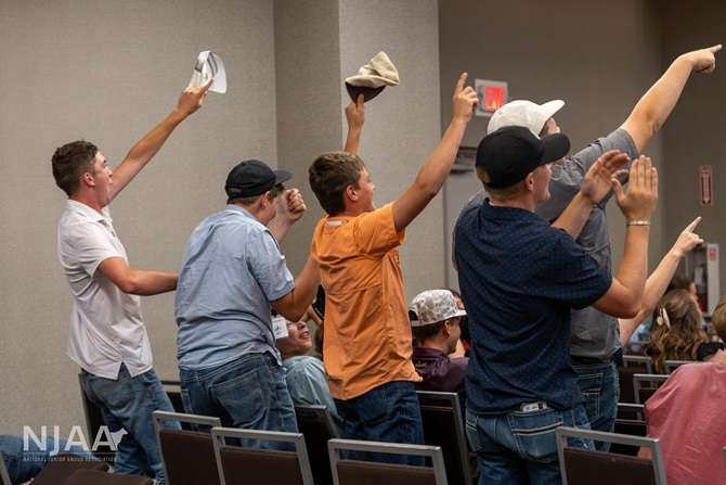 Participants cheering and raising hats during an interactive activity.