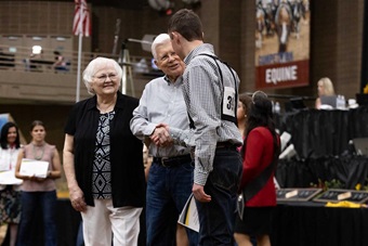 Scholarship award winner receiving handshake from donor.