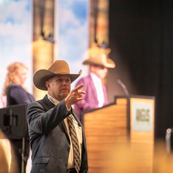 An auctioneer takes a bid during the Angus Foundation raffle during the awards dinner at the American Angus Association Annual Convention.