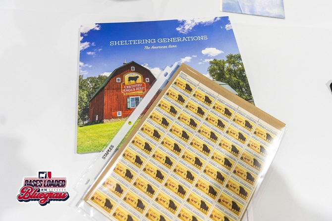 Certified Angus Beef commemorative stamp sheet and brochure displayed on a silent auction table.
