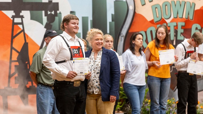 A young NJAA member accepts a scholarship at the National Junior Angus Show.