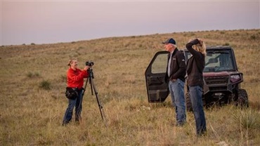 Person filming cattle producer in a field for an interview.