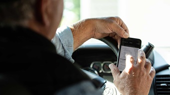 Rancher using cellphone to look up data