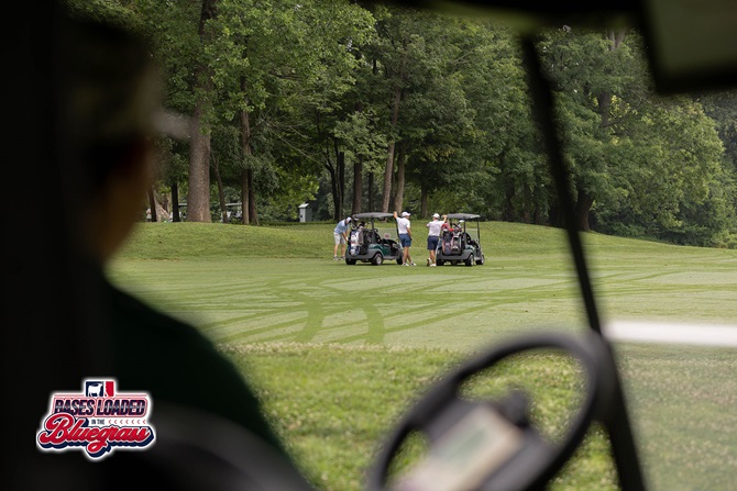 Golfers gather beside their carts between shots during the tournament.