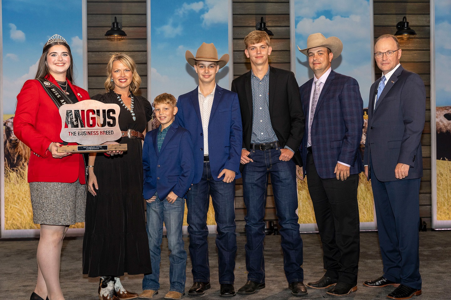  Josh Worthington accepts his award on November 1 for 2025 Young Breeder of the Year on stage in Kansas City, Missouri during Angus Convention. Pictured from Left: Rosalind Kidwell, 2025 Miss American Angus; Corry Worthington, wife; sons Corbin, Grayson and Wriston Worthington; Josh Worthington; and Mark McCully, American Angus Association® CEO. 