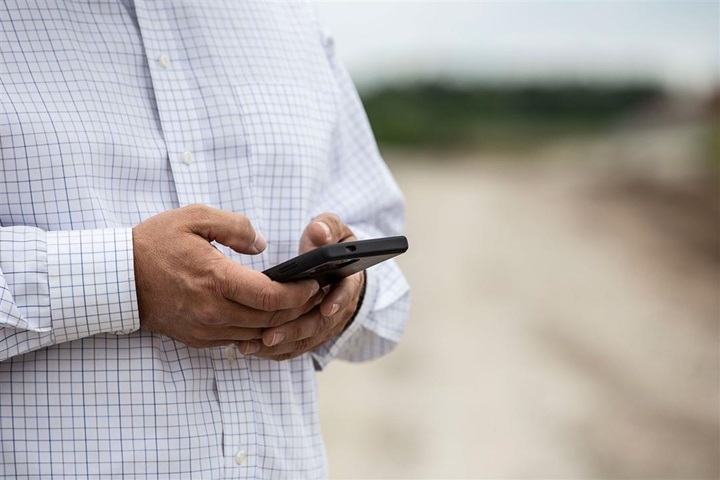 A producer looks at data on his phone.