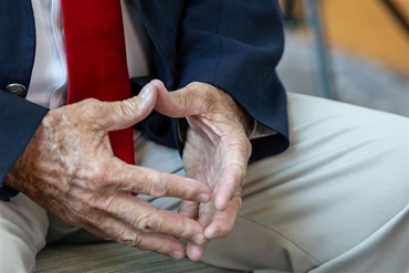 A man clasping his hands together in contemplation.