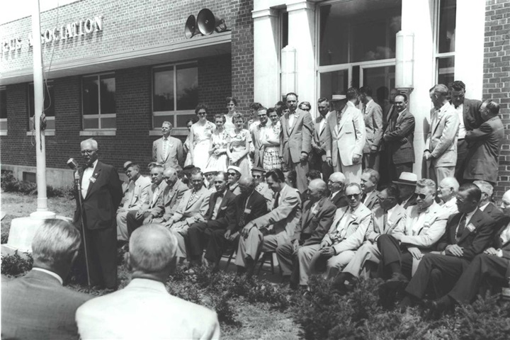 A group of individuals in the 1950's standing outside of the American Angus Association headquarters.