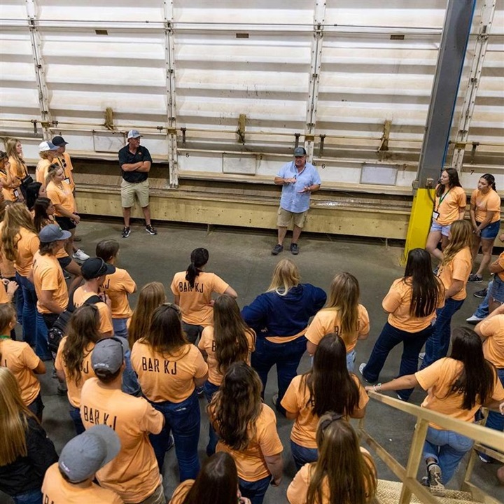 A large group of NJAA members listening to a speaker in a warehouse area during the 2023 LEAD Conference.