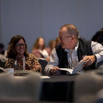 Two attendees laugh together at the American Angus Association Annual Convention.