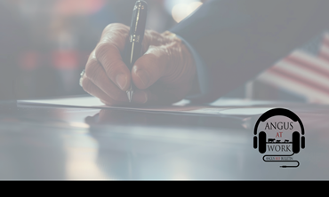 Man holding a pen with an American flag in the background.