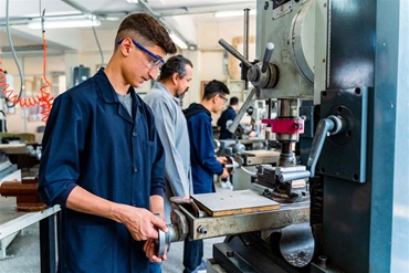 A young student participates in his vocational training in a mechanics shop.