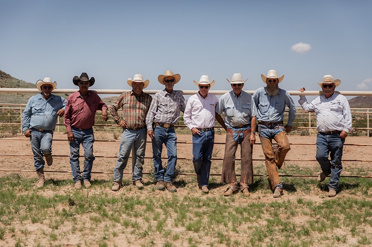 several men standing next to a fence