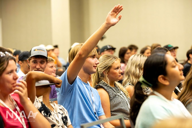 Audience member raising a hand to participate in a session.