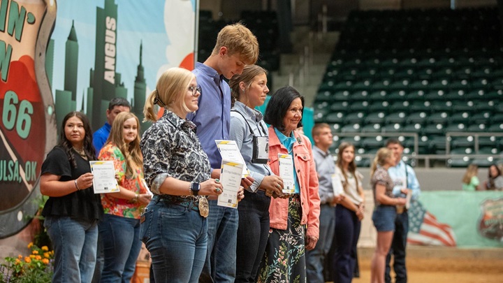 Students standing in a line accepting their scholarship awards at the National Junior Angus Show.