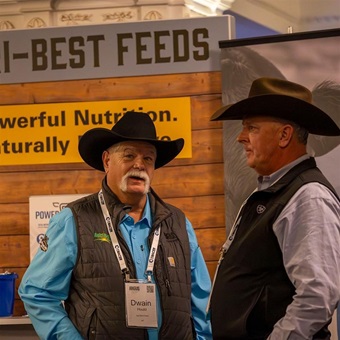 Two men in cowboy hats discuss together at the Industry Showcase during Angus Convention.