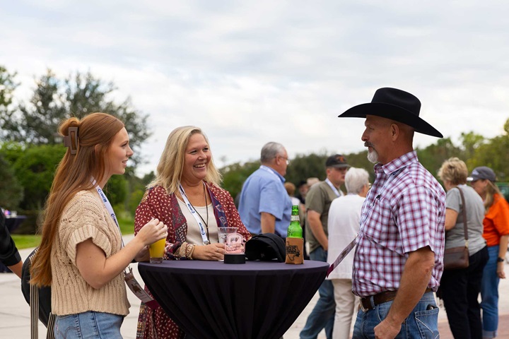 Convention attendees standing around a table chatting.