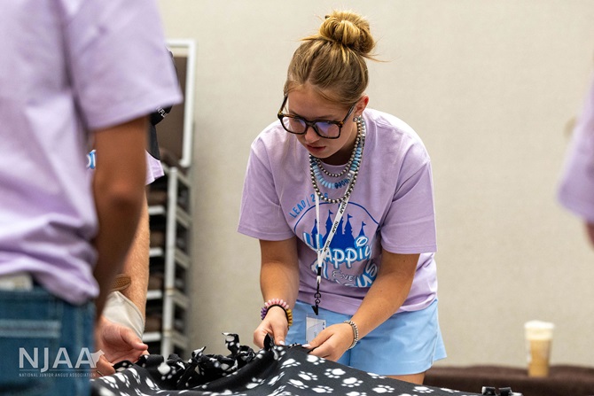 Participant tying blanket edges during a service project.