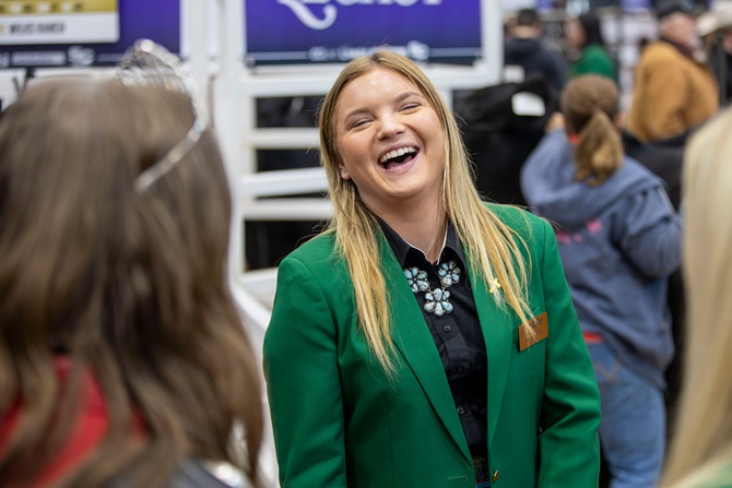 Member of the NJAA Junior Board, Lexi Koelling, laughs as she speaks with patrons of the 2026 Angus Foundation Heifer Package sale.