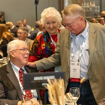 A group of attendees welcome one another at the Angus Convention Awards Dinner.