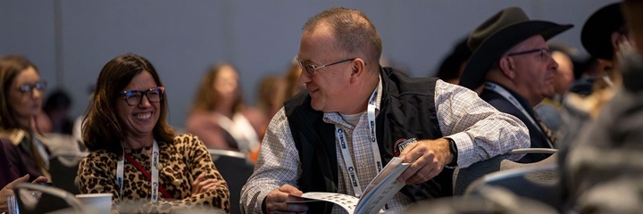 Two attendees laugh together at the American Angus Association Annual Convention.