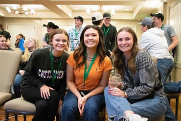 Three female junior members sitting together at the Raising the Bar conference.