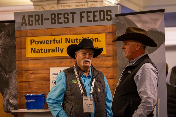 Two men in cowboy hats discuss together at the Industry Showcase during Angus Convention.