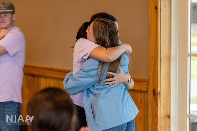 Two NJAA participants sharing a hug indoors.
