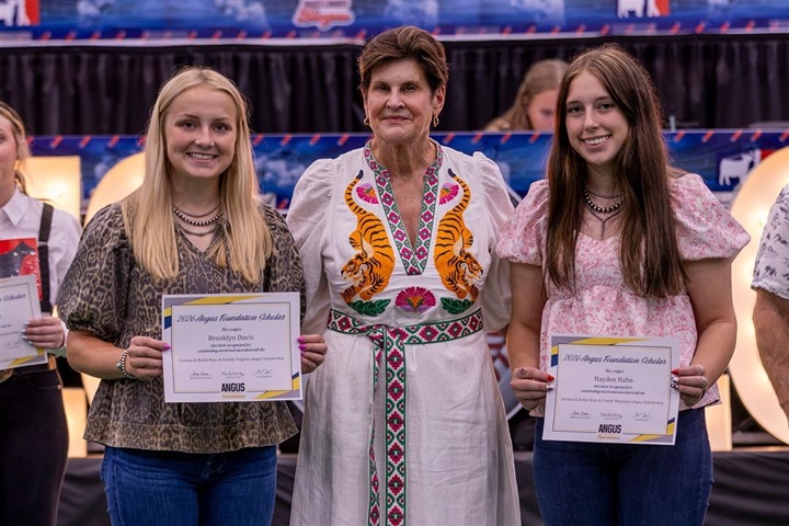 Angus Foundation scholarship recipients stand on stage holding certificates during a scholarship recognition ceremony at the National Junior Angus Show.