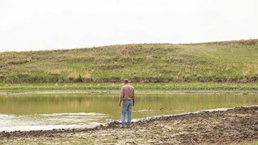 man next to dry pond