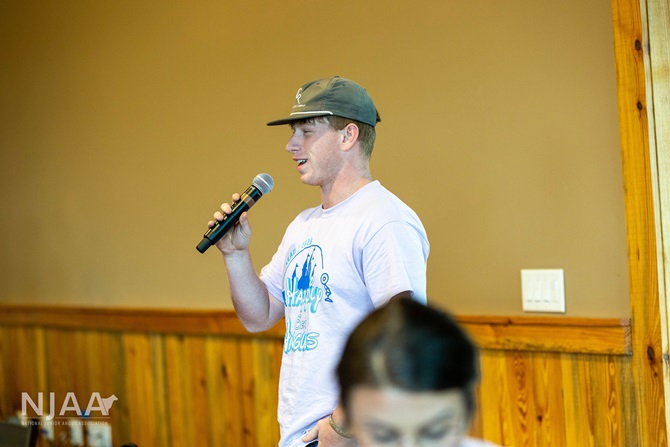 NJAA participant speaking into a microphone during a group session.