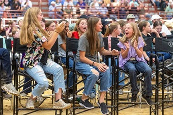 Group of young girls clapping and celebrating their friend, who just received an award at the National Junior Angus Show.