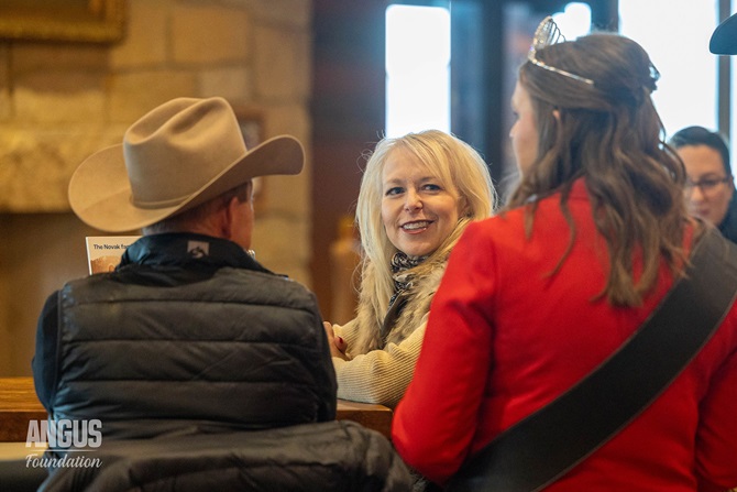 Claire Murnin, 2026 Miss American Angus queen, speaks to perspective donors at the NWSS Herdsman social event.