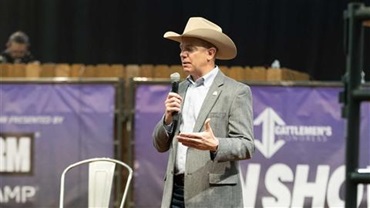 Man in a cowboy hat speaking on a mic.