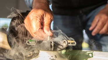 Individual pulling a semen straw out of a semen tank full of nitrogen