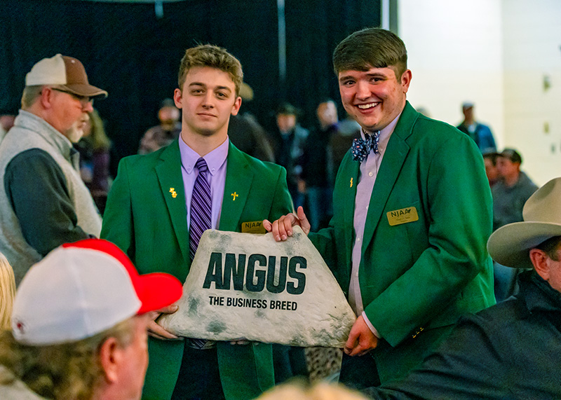two boys holding a stone
