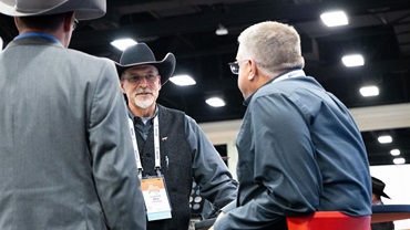 A group of Angus cattlemen speaking to one another at an Angus event.