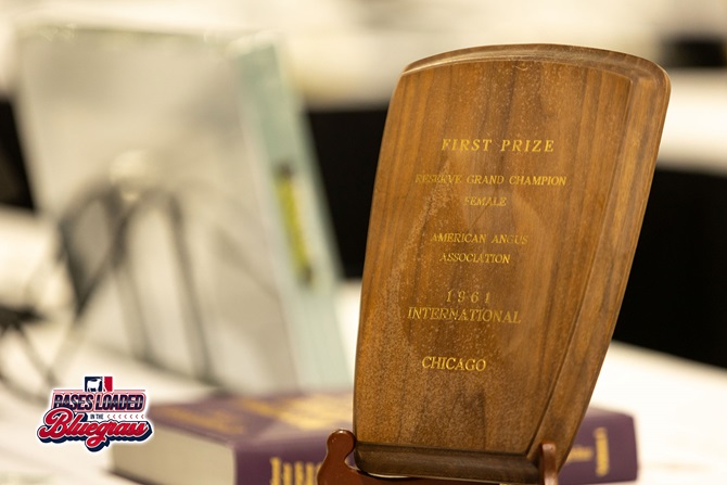 Historic wooden award plaque from the American Angus Association displayed on a table at the silent auction.