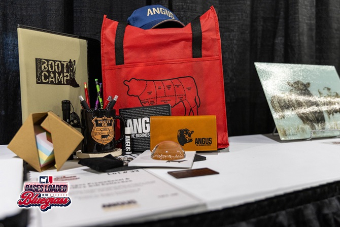 Angus-themed merchandise package featuring a tote bag, cap, mug, notebook, and promotional items.