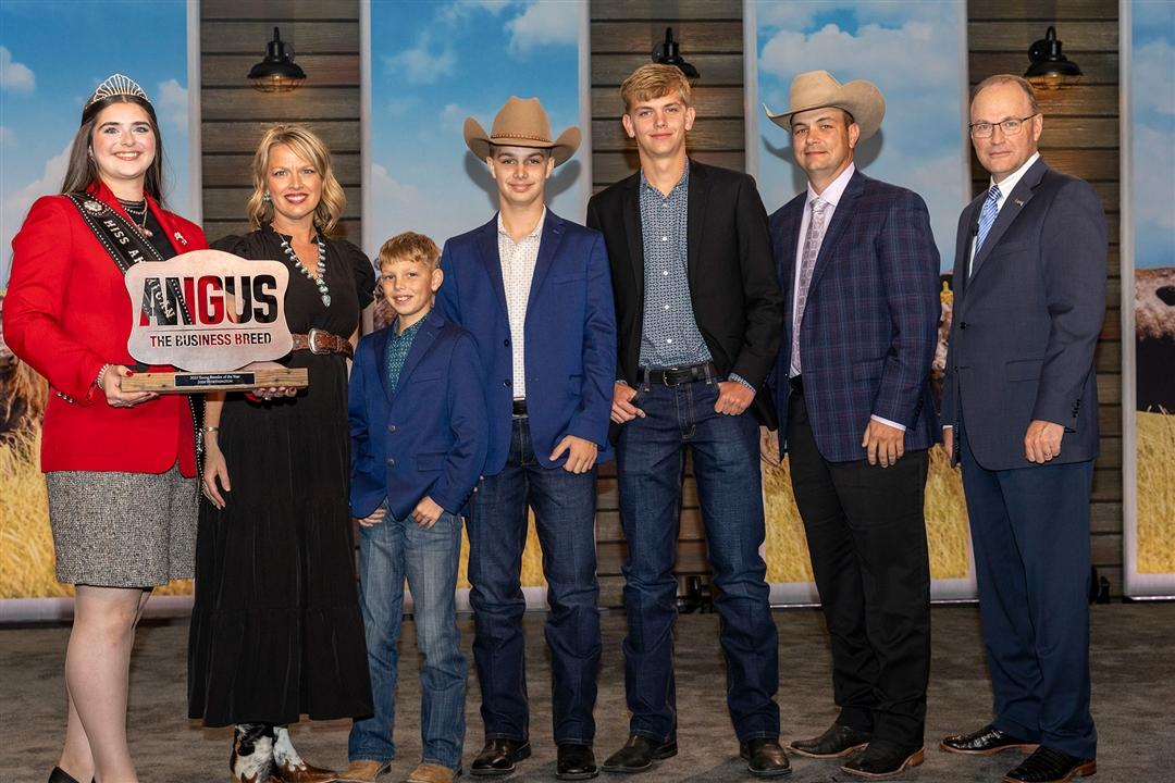  Josh Worthington accepts his award on November 1 for 2025 Young Breeder of the Year on stage in Kansas City, Missouri during Angus Convention. Pictured from Left: Rosalind Kidwell, 2025 Miss American Angus; Corry Worthington, wife; sons Corbin, Grayson and Wriston Worthington; Josh Worthington; and Mark McCully, American Angus Association® CEO. 