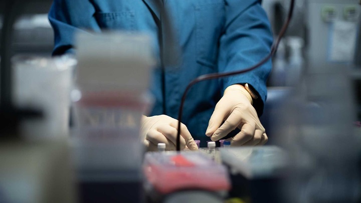 Xcientist holding equipment in a lab