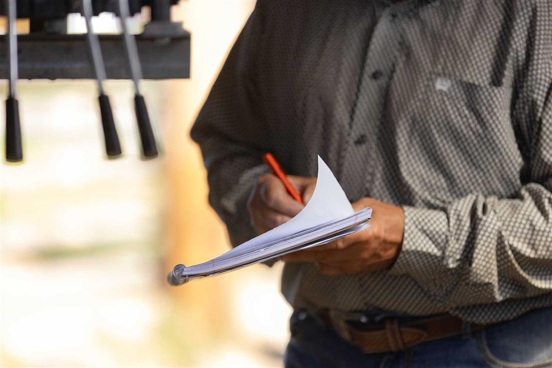 Individual next to working chute writing down important information collected during processing.